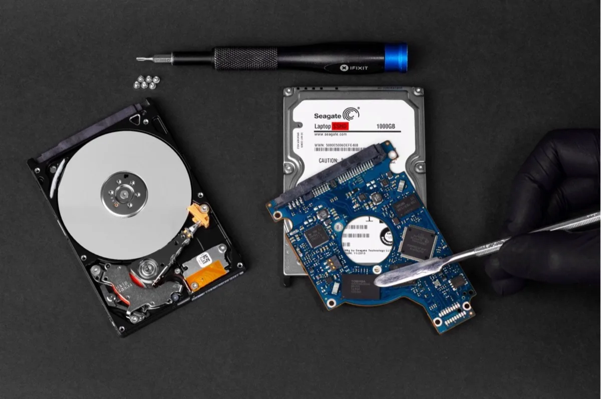 Technicien réparant un disque dur en salle blanche - récupération de données professionnelle